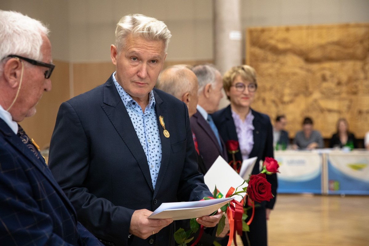 Dyrektor Lubuskiego Teatru, Robert Czechowski, trzyma w dłoniach różę i order. W tle pani Marszałek z osobami towarzyszącymi.
